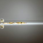 a pair of gold coins sitting on top of a reflective surface